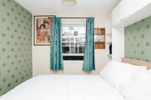 um quarto com uma cama e uma janela com cortinas azuis em The Limes-3 bed, central Henley em Henley on Thames