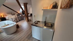 uma cozinha com um lavatório e uma banheira num quarto em Dream Boutique Edam Bed & Coffee em Edam
