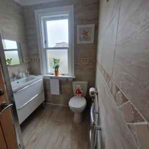 a bathroom with a toilet and a sink and a window at 3 Bedroom Apartment max 5 Pax Musselburgh in Musselburgh