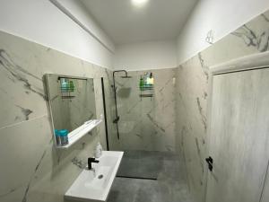 a white bathroom with a sink and a shower at Olive apartment in Podgorica