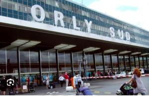 un grupo de personas caminando fuera de un aeropuerto en Magnifique T2 à 5 mn de l'aéroport d'Orly en Paray-Vieille-Poste