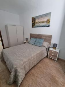 a bedroom with a bed and a painting on the wall at AT SAN PEDRO 1 in Olivenza