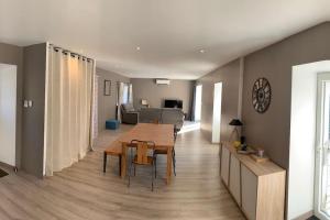 ein Esszimmer und ein Wohnzimmer mit einem Tisch und Stühlen in der Unterkunft Le gîte de Moulinas in Giffon