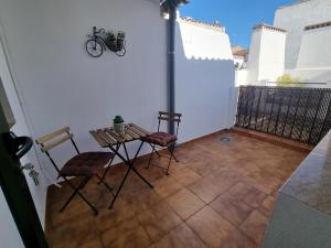 patio ze stołem i krzesłami na balkonie w obiekcie AT SAN PEDRO 1 w mieście Olivenza