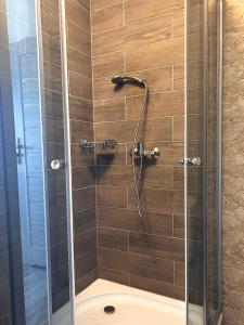 een douche met een glazen deur en een douche bij Apartamenty Golf Dyndeby in Neksø