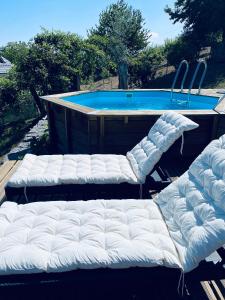 two white beds sitting in front of a swimming pool at Casa da Venda Spa - Vista Gerês in Montalegre