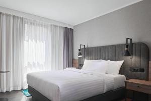 a bedroom with a large bed and a large window at Residence Inn by Marriott Essen City in Essen