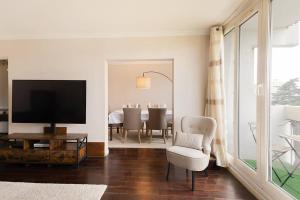 a living room with a tv and a chair and a table at Magnifique appartement entre Disneyland et Paris 3 Chambres in Neuilly-sur-Marne