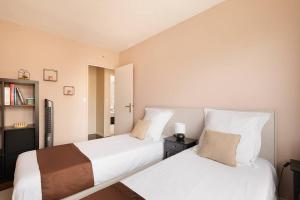 1 dormitorio con 2 camas y estante para libros en Location chic 3 chambres proche Paris & Disneyland, en Neuilly-sur-Marne