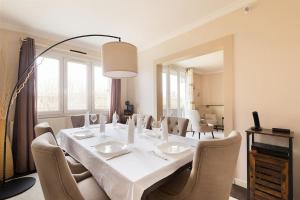 a dining room with a white table and chairs at Magnifique appartement entre Disneyland et Paris 3 Chambres in Neuilly-sur-Marne +4 photos