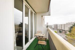 un balcón con 2 sillas y una mesa. en Location chic 3 chambres proche Paris & Disneyland, en Neuilly-sur-Marne