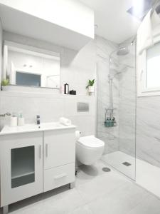 a white bathroom with a sink and a toilet at Nuevo Hola Madrid Alojamiento Temporal in Madrid