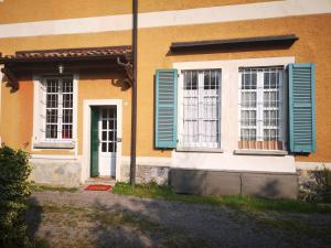 Casa Vacanze Agnello في Grandola ed Uniti: منزل به نوافذ مغلقه زرقاء وباب