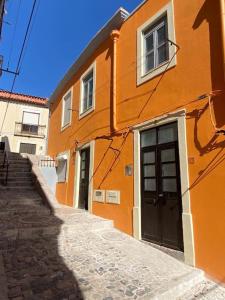 ein orangefarbenes Gebäude mit einer Treppe neben einer Straße in der Unterkunft Holiday Setúbal Loft in Setúbal