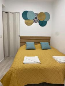 ein Schlafzimmer mit einem gelben Bett mit blauen Kissen in der Unterkunft Holiday Setúbal Loft in Setúbal