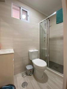 a bathroom with a toilet and a glass shower at Holiday Setúbal Loft in Setúbal