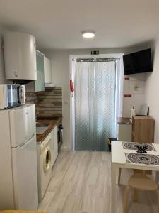 a small kitchen with a refrigerator and a sink at Holiday Setúbal Loft in Setúbal