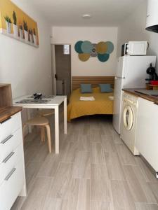 a small kitchen with a bed and a table and a refrigerator at Holiday Setúbal Loft in Setúbal