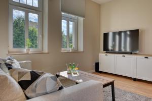 a living room with two couches and a flat screen tv at Apartament Wiesental in Polanica-Zdrój