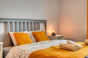 a bedroom with a large bed with yellow pillows at Apartament Wiesental in Polanica-Zdrój