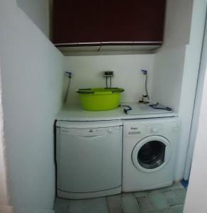 een wasmachine met een gele kom erop bij Casa Vacanze Agnello in Grandola ed Uniti
