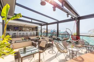 a rooftop patio with tables and chairs and a bar at Your Corner in Batumi ! in Batumi