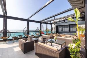 an outdoor patio with chairs and tables and the ocean at Your Corner in Batumi ! in Batumi