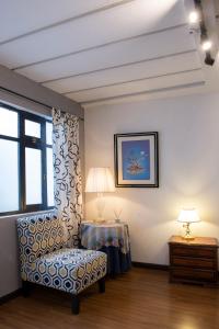 um quarto com uma cadeira, uma mesa e uma janela em Suite bien ubicada con entrada independiente em Cuenca