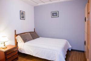 um pequeno quarto com uma cama e uma mesa de cabeceira em Suite bien ubicada con entrada independiente em Cuenca