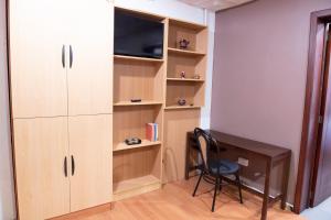 um quarto com uma secretária e um armário com uma televisão em Suite bien ubicada con entrada independiente em Cuenca