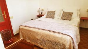 1 dormitorio con 1 cama con sábanas y almohadas blancas en Casa Vacanze Agnello en Grandola ed Uniti