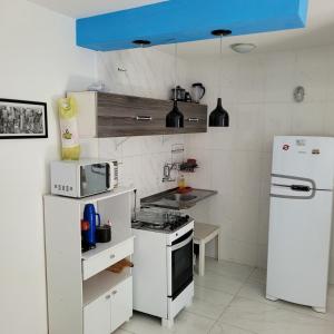 a kitchen with white appliances and a blue ceiling at Apartamento Itagarça - Praia de Itaparica in Vila Velha