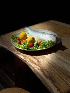 a plate of vegetables on a wooden table at Posh Villas in Rrogozhinë