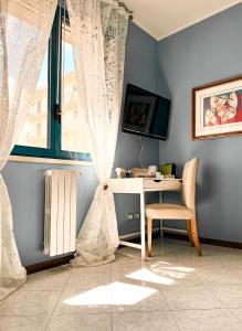 een kamer met een bureau en een raam met een stoel bij Claire Rose B&B in Matera