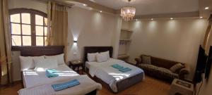 ein Hotelzimmer mit 2 Betten und einem Sofa in der Unterkunft Pyramids Kingdom in Kairo