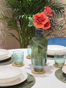 einen Tisch mit Platten und eine Vase mit Blumen darin in der Unterkunft La Piazzetta Guest House in Neapel