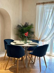 einen Tisch mit Stühlen und eine Vase mit einer Blume darauf in der Unterkunft La Piazzetta Guest House in Neapel
