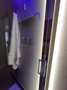 ein Badezimmer mit einem Kühlschrank und einem weißen Handtuch in der Unterkunft La Piazzetta Guest House in Neapel