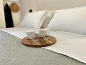 ein Tablett mit zwei Kerzen und zwei Gläsern auf einem Bett in der Unterkunft La Piazzetta Guest House in Neapel