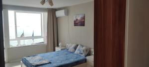 a small bedroom with a bed and a window at SEA VIEW FLORA in Burgas