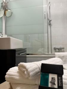 een badkamer met handdoeken, een wastafel en een douche bij Claire Rose B&B in Matera