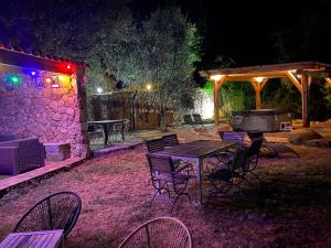 ein Picknicktisch und Stühle im Garten in der Nacht in der Unterkunft Résidence A CASA VECCHIA gites de charme avec JACUZZI proche Ajaccio in Peri