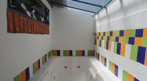 a bathroom with a bath tub with colorful tiles at Suites Arcoiris in Villa de Leyva