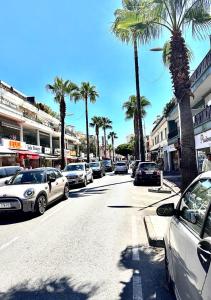 uma rua com carros estacionados ao lado de uma rua com palmeiras em Charmant 2 Pièces em Antibes