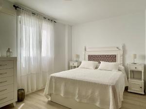 een witte slaapkamer met een wit bed en een dressoir bij Apartamento Ronda Centro in Ronda