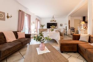 ein Wohnzimmer mit einem Sofa und einem Tisch in der Unterkunft villa grand mère marie in Brazey-en-Plaine