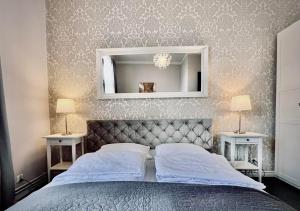 una camera da letto con un letto con uno specchio e due tavoli di Apartamenty Długa 27 a Cracovia