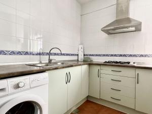 een keuken met een wastafel en een wasmachine bij Apartamento Ronda Centro in Ronda