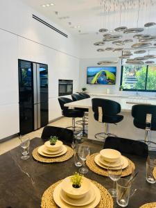 een woonkamer met tafels en stoelen en een keuken bij Luxurious house in Ness Tziona in Nes Ẕiyyona