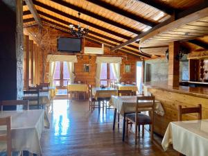 a dining room with tables and chairs and a tv at Hostal Caulle in Río Bueno